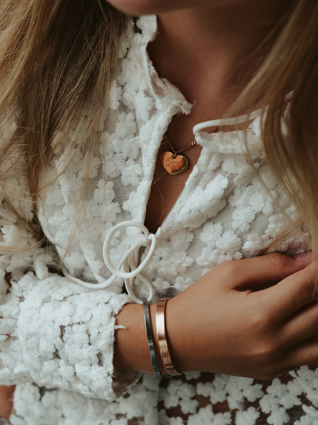 Image that has a pretty girl sitting by water showing bracelet